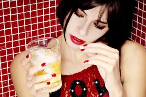 young woman taking BZD pills with alcohol