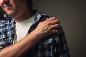 man with shoulder pain due to hangover