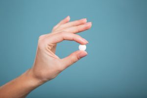 woman holding disulfiram pill