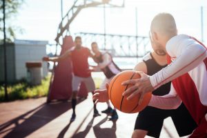 group of men playing basketball outside
